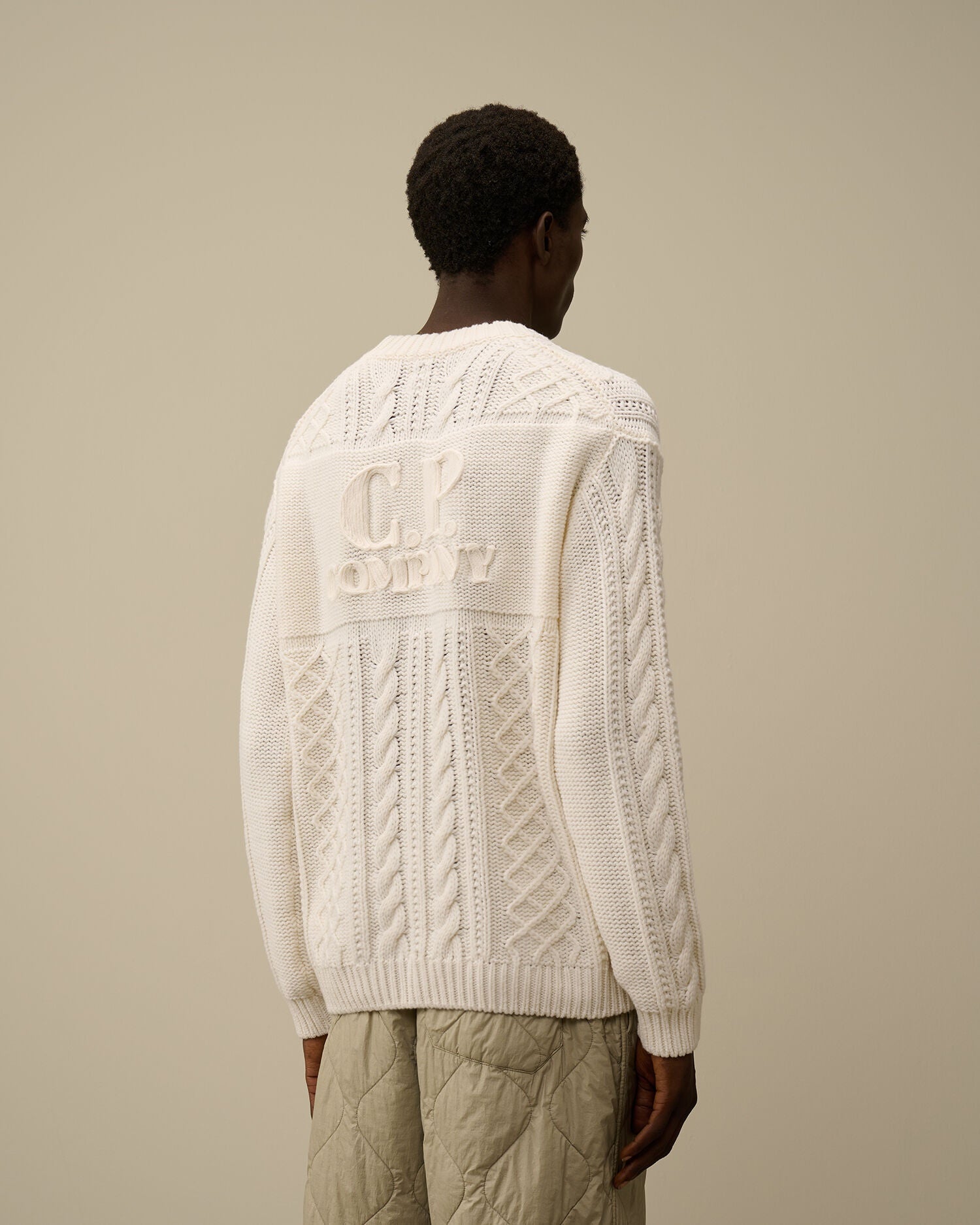CP Company cream white cable-knit wool-blend sweater with front embroidered logo.
