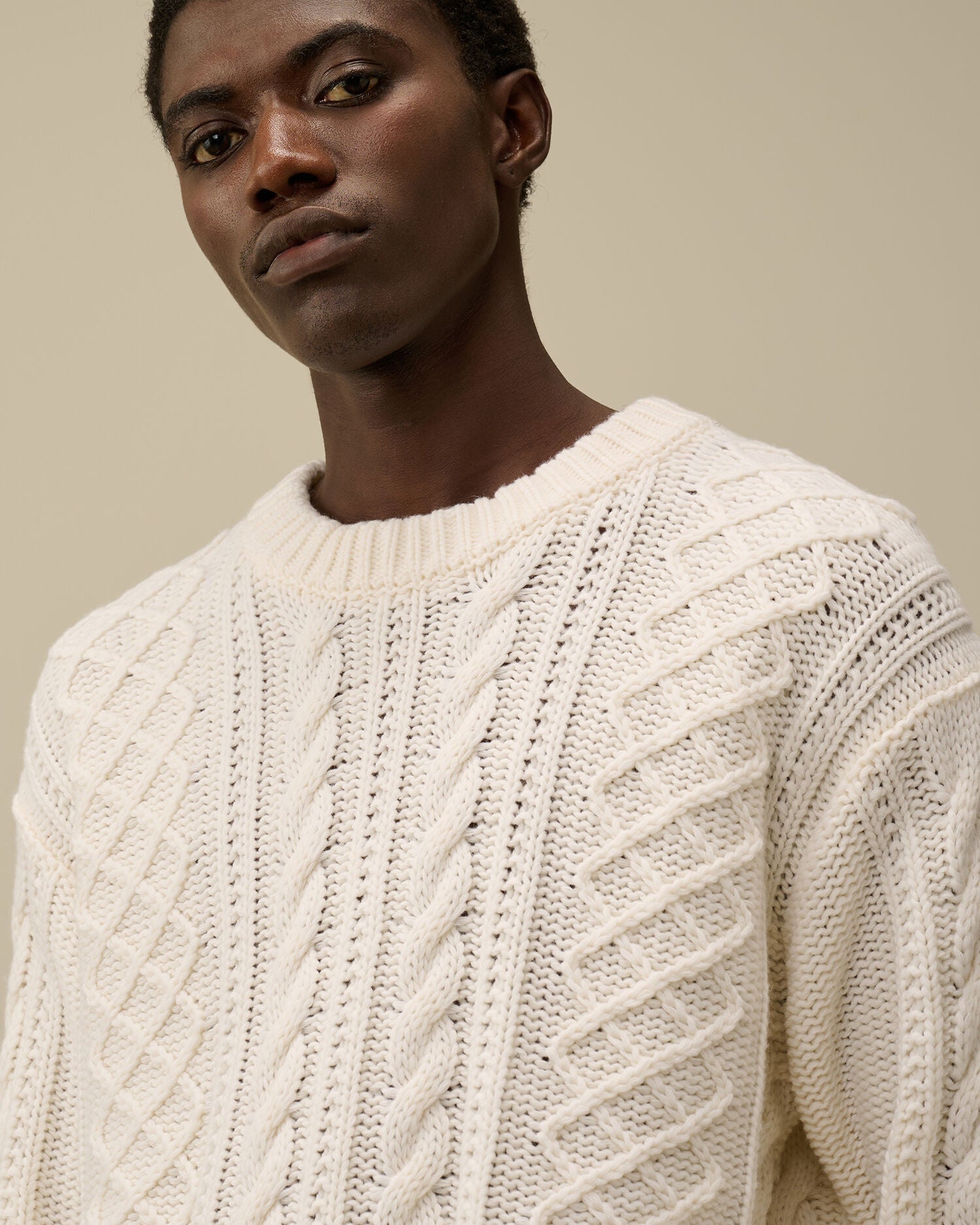 CP Company cream white cable-knit wool-blend sweater with embroidered logo, close view
