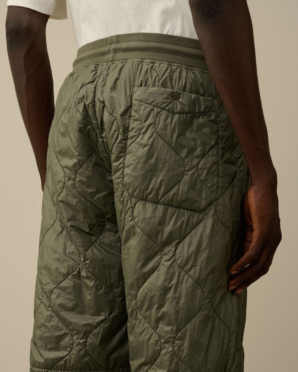 Back pocket close detail with button on the CP Company camo green quilted straight trousers
