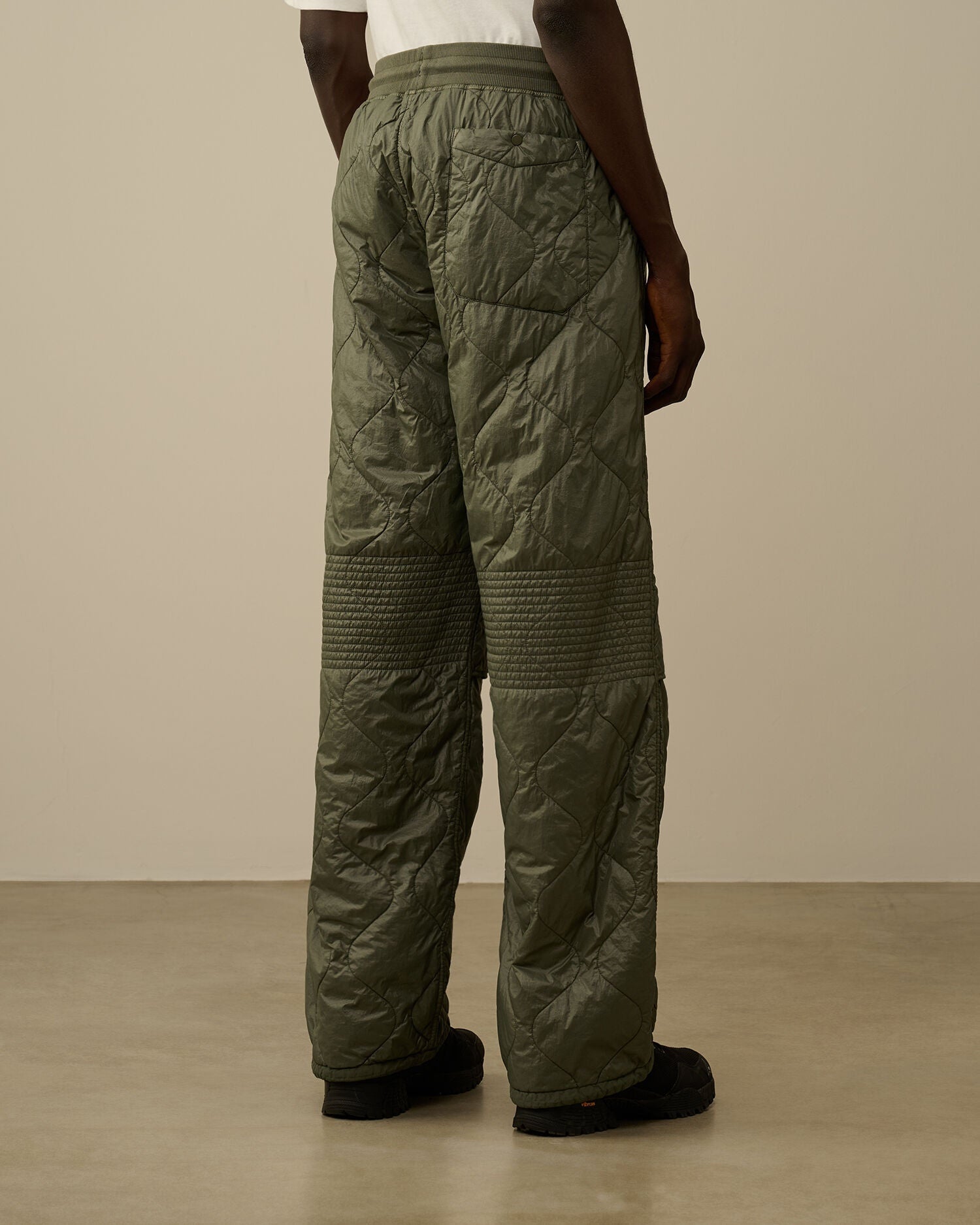 Back pocket detail with button on the CP Company camo green quilted straight trousers.
