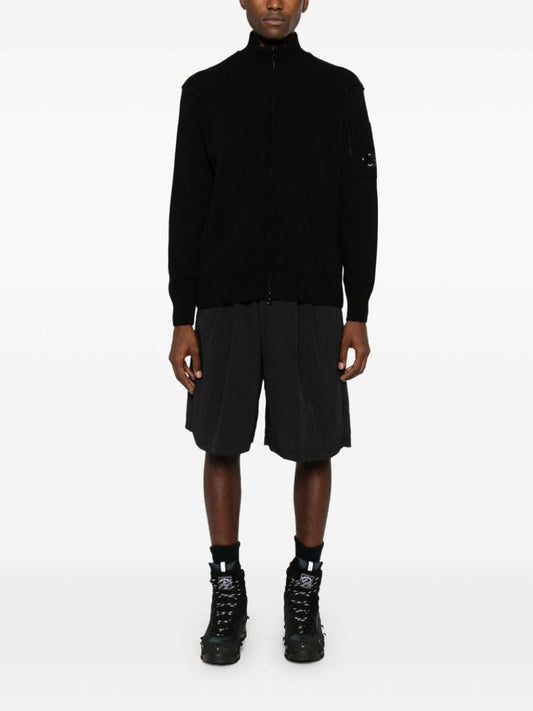 Full view of the CP Company labswool lens-detailed zipped cardigan sweater in black.
