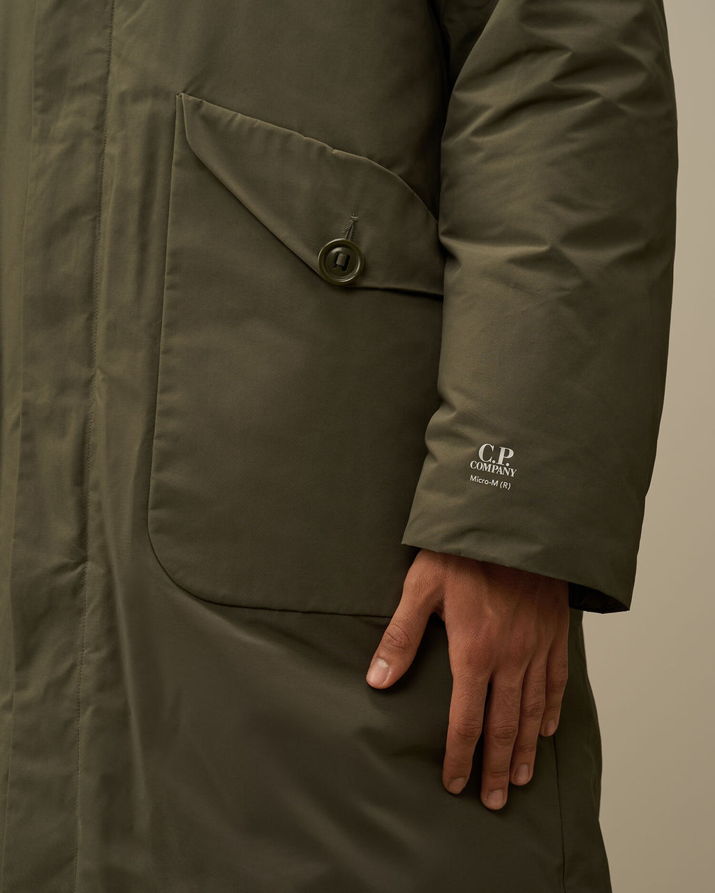 Printed CP Company logo detail on the left wrist of the green Micro-M (R) down parka.

