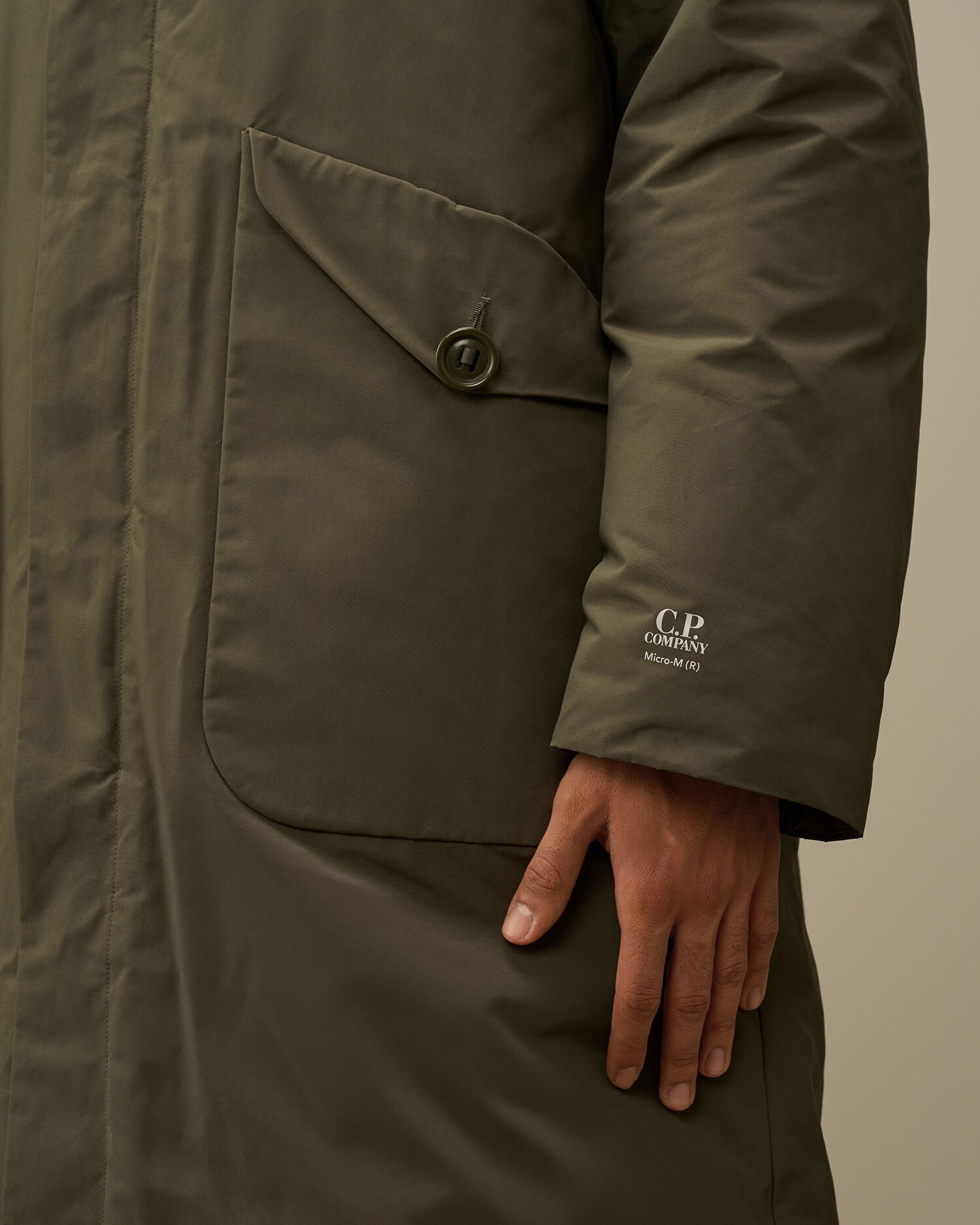 Printed CP Company logo detail on the left wrist of the green Micro-M (R) down parka.
