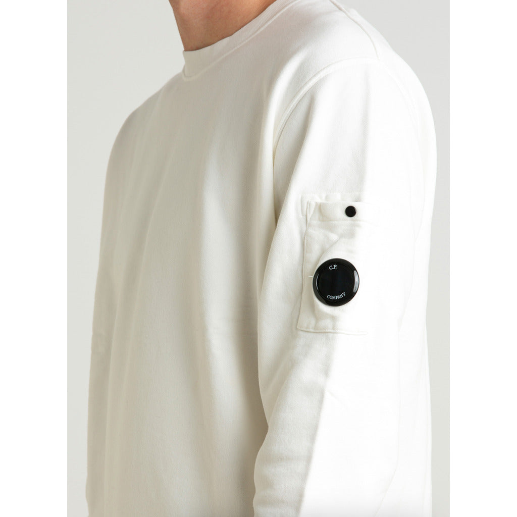 Close-up of the iconic CP Company goggle on the side zip pocket of the white unisex sweater