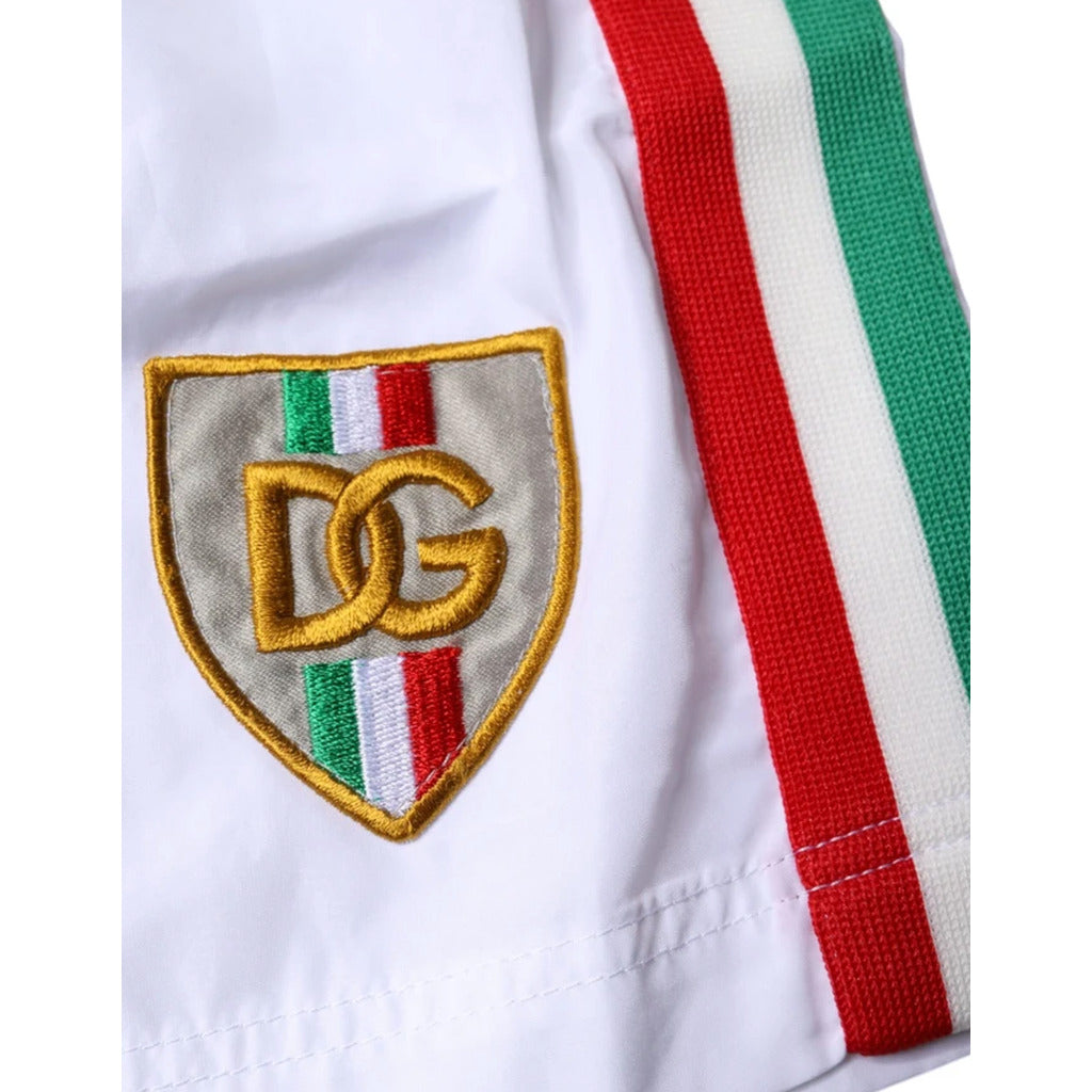 Detail of the embroidered Dolce & Gabbana logo patch on the front of white shorts
