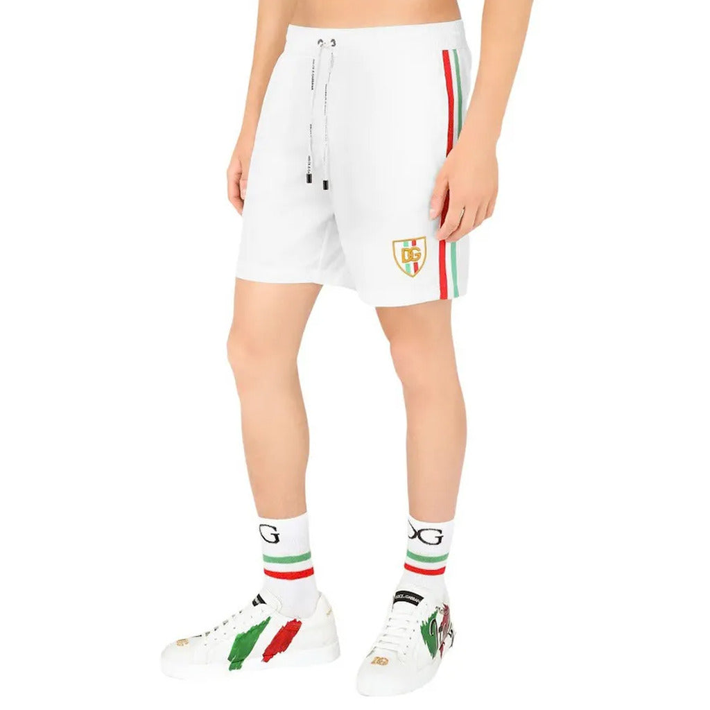 Model wearing the Dolce & Gabbana white shorts with red green stripe details
