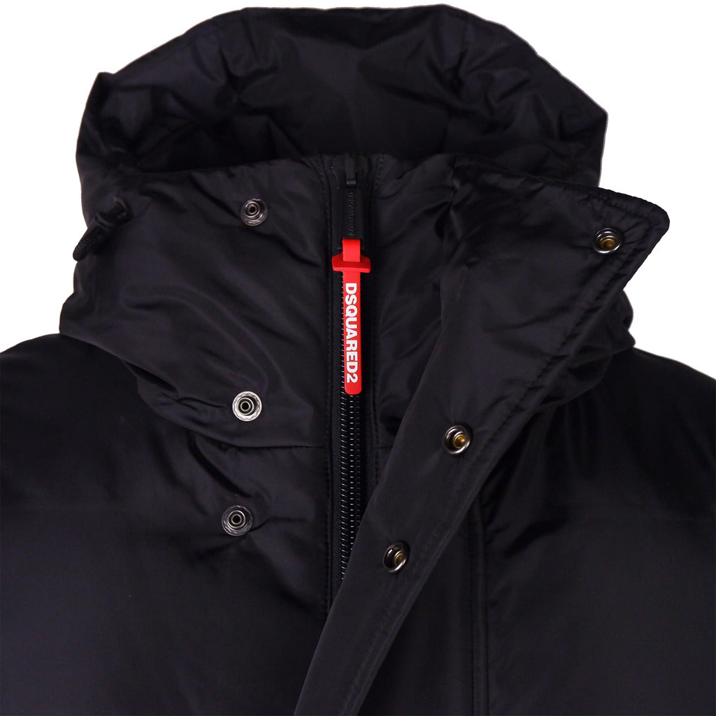 Close up showing the zip and button front closure of the Dsquared2 black puffer coat
