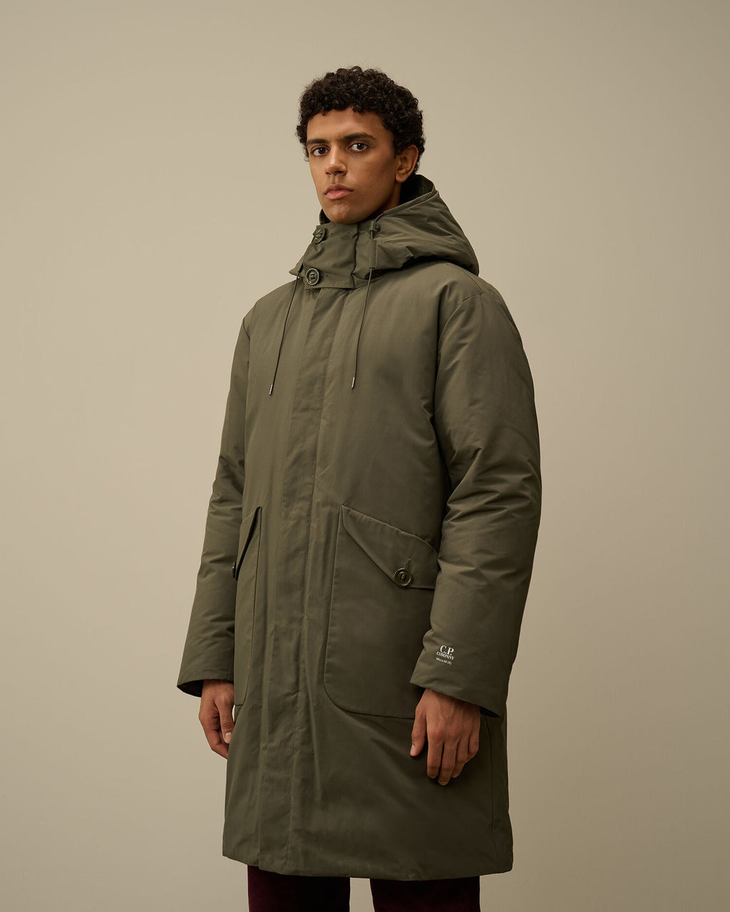 Model showcasing the regular fit of the CP Company Micro-M (R) down parka in green