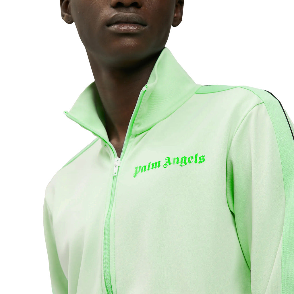 Close-up of the Palm Angels printed logo on the chest of the green track jacket
