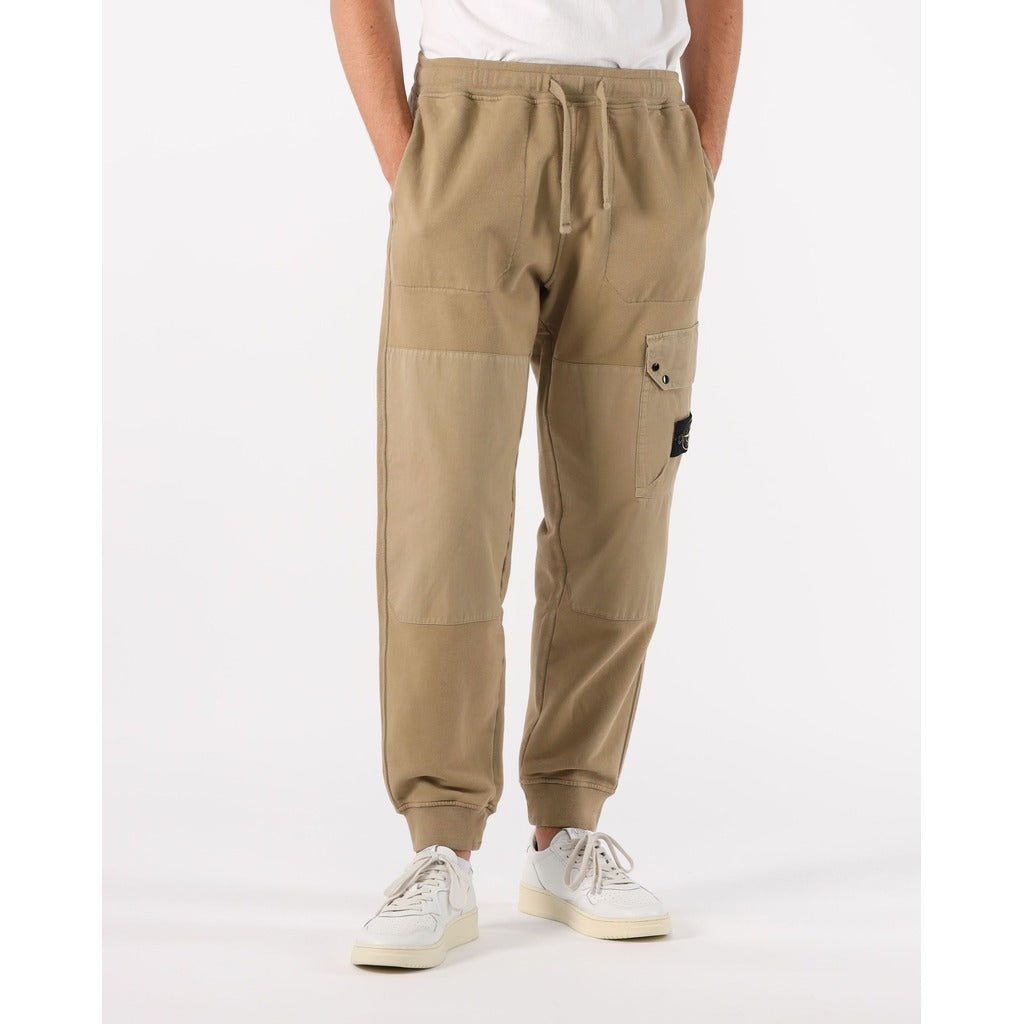 Close-up of the Stone Island badge on the buttoned cargo pocket of the beige sweatpants.
