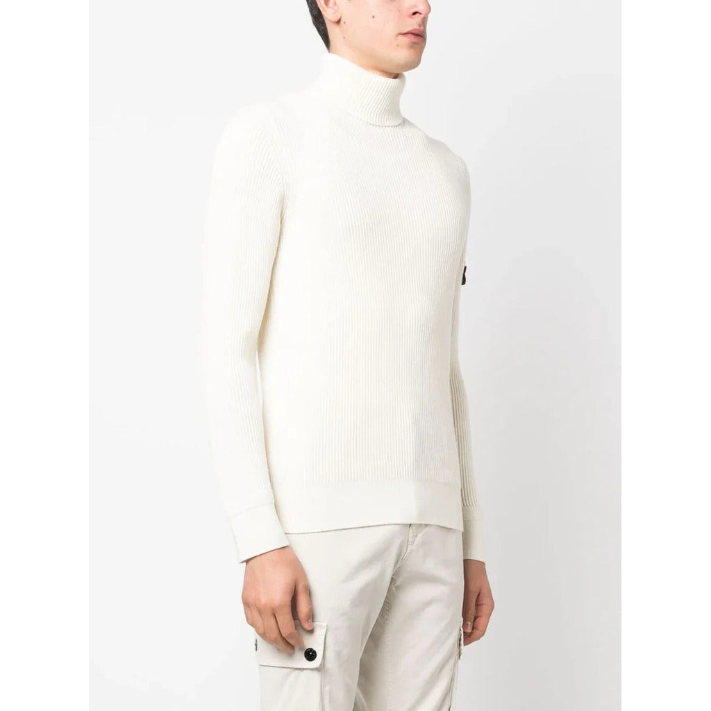 Close-up of the detachable Stone Island Compass badge on the ivory wool sweater sleeve.
