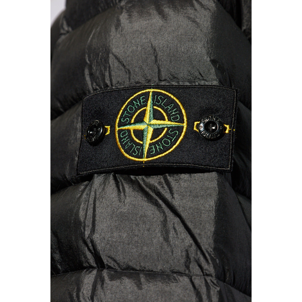 Close-up of the Stone Island Compass logo patch on the sleeve of the black down jacket