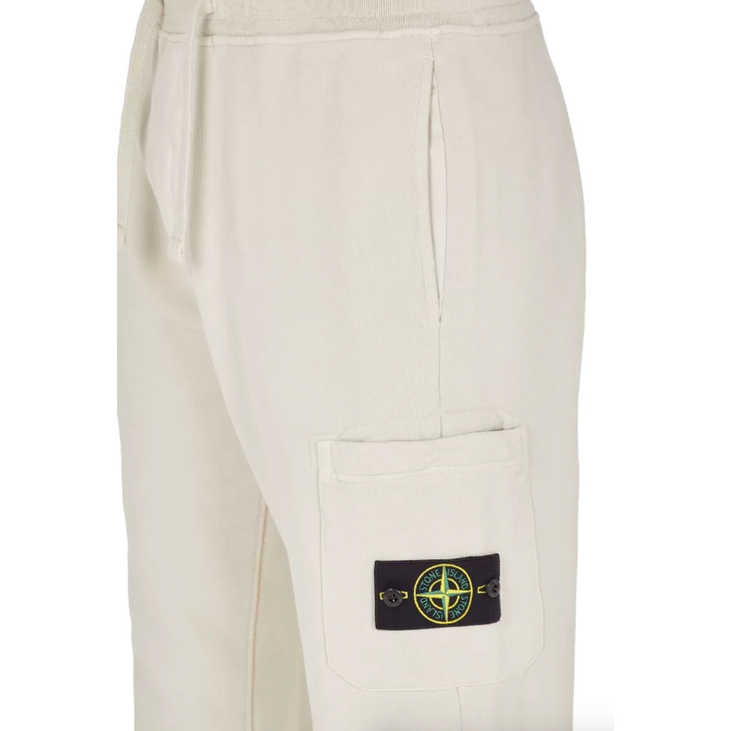 Close-up of Stone Island badge on the zip leg pocket of the white joggers.

