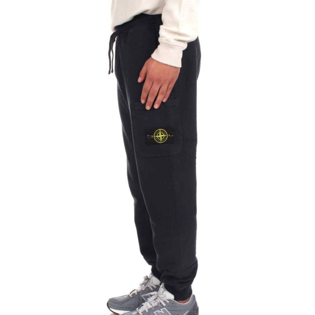 Close-up of Stone Island logo patch on the zip leg pocket of the joggers.
