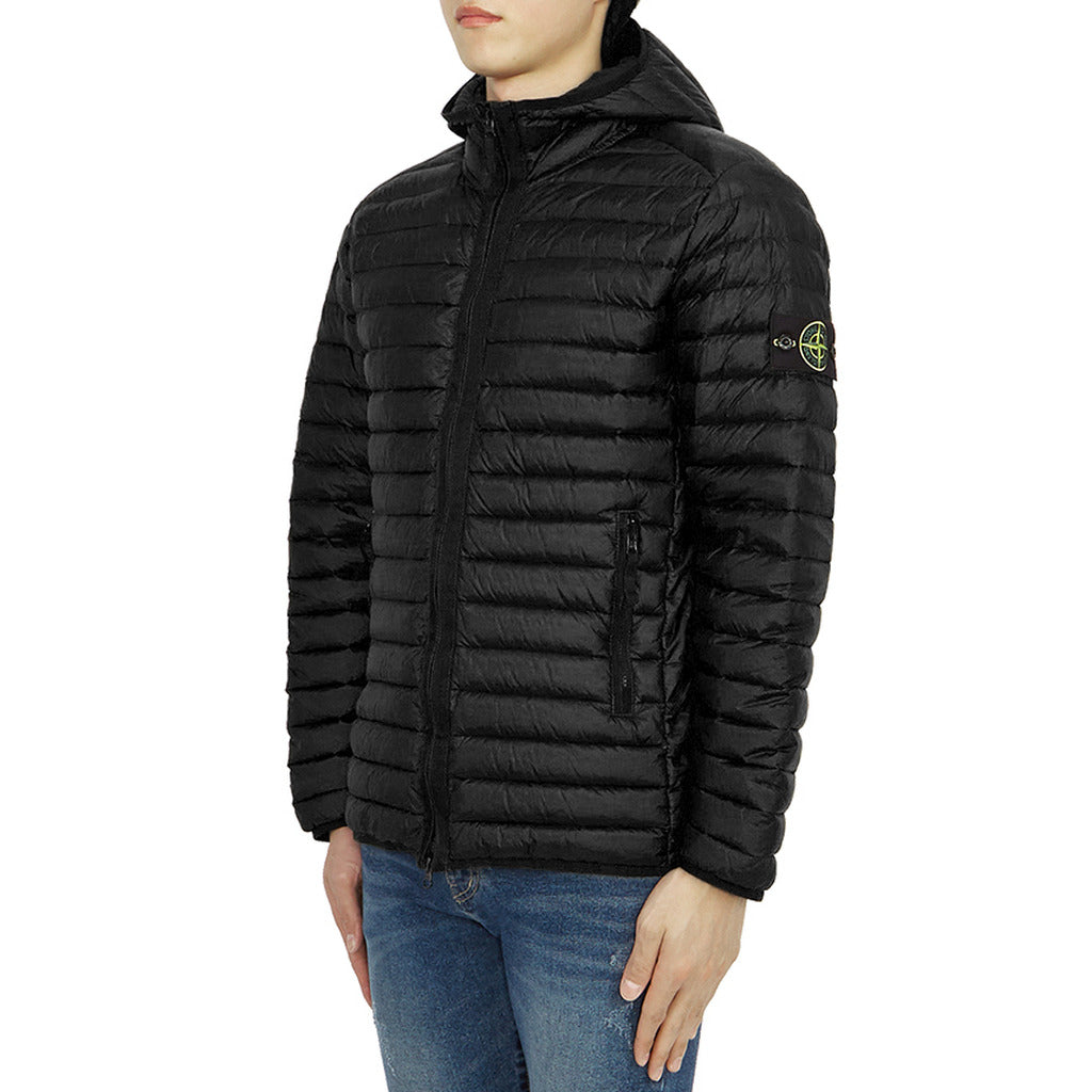 Close-up of the Stone Island logo patch on the sleeve of the black down jacket.
