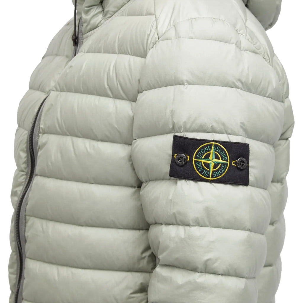 Close-up of the Stone Island logo patch on the sleeve of the grey down jacket.
