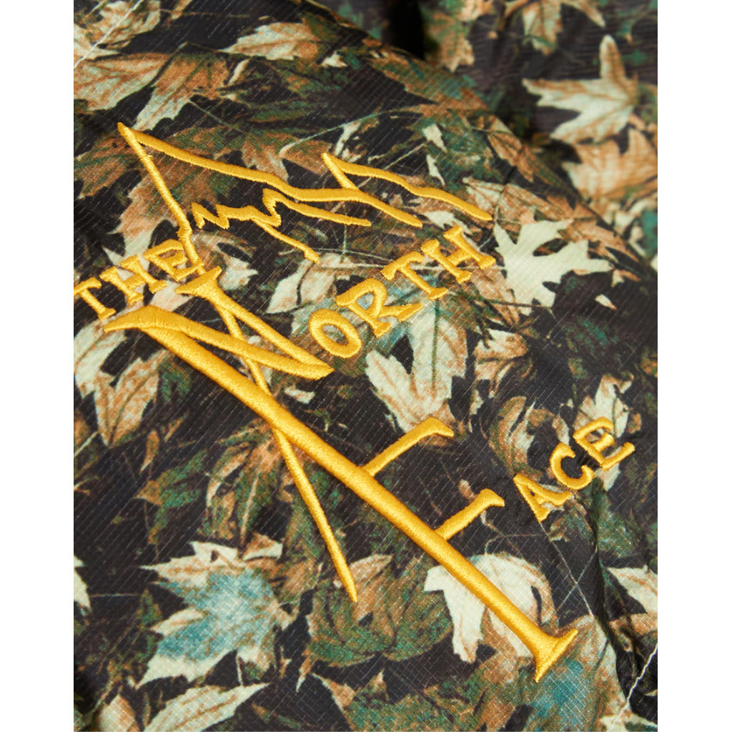 The North Face logo detail on the chest or sleeve of the green camo parka.
