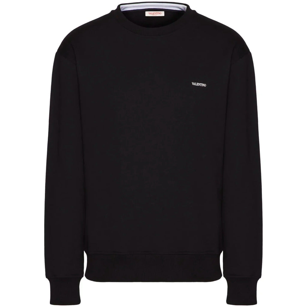Close-up detail of the Valentino logo print on the chest of the black cotton sweatshirt.
