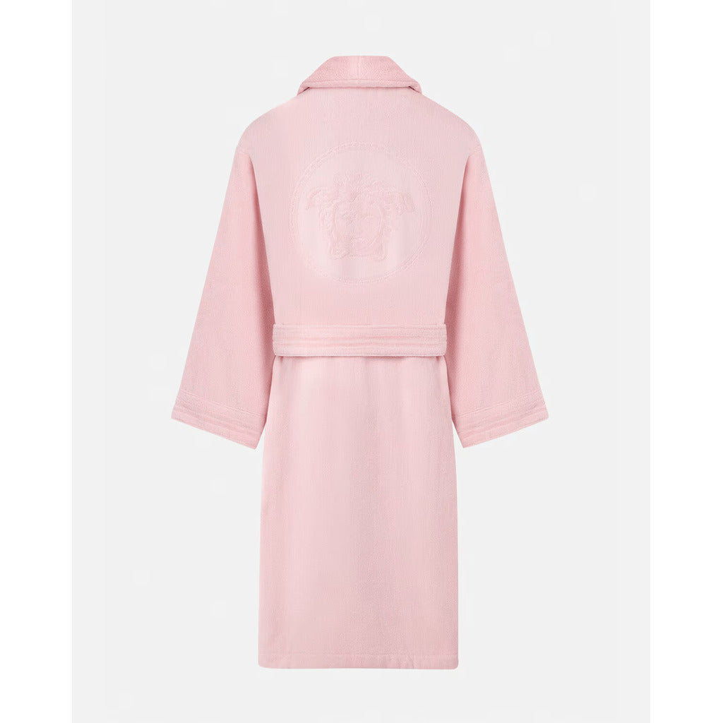 Close-up detail of the iconic Medusa head on the back of the Versace pink bathrobe.
